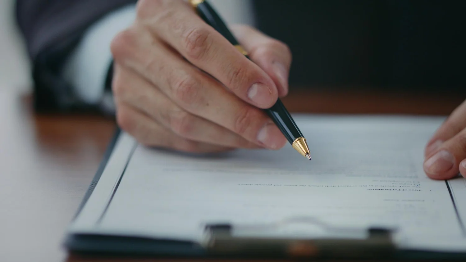 mão com caneta assinando documento de proposta vinculante