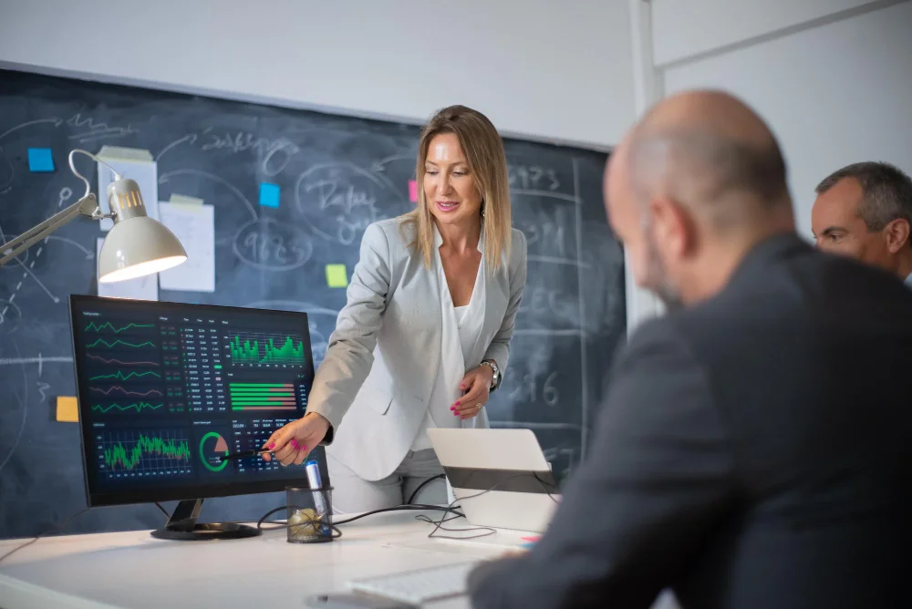 mulher apresentando graficos financeiros de fusões e aquisições m&a